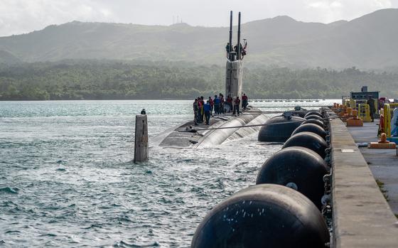 A submarine pulls in to a dock.