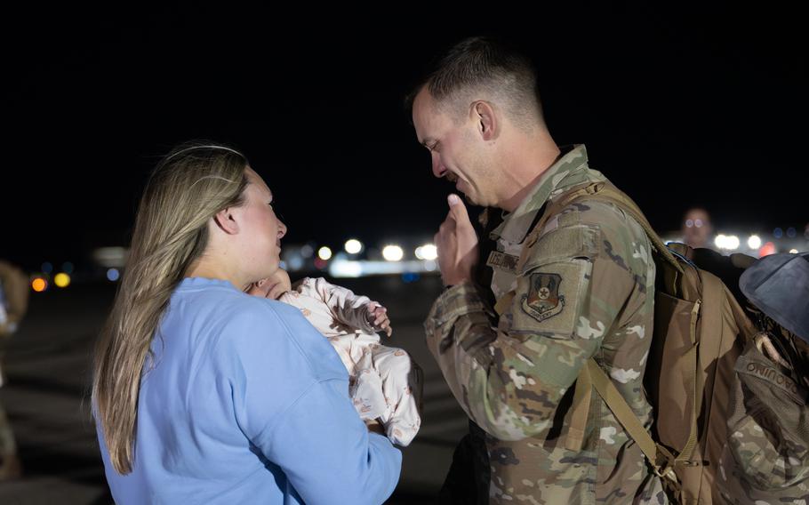 An airman greets his wife and baby