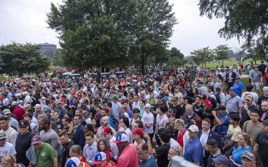 A crowd of people walking from an empty field.