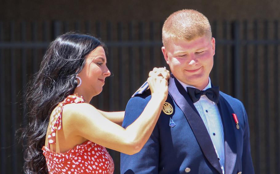 Tanner Johnson's fiancee, Brynn Woodyard, pins on his second lieutenant bars at the commissioning ceremony for Cadet Squadron 14 at the U.S. Air Force Academy in Colorado Springs, Colo., May 25, 2021. Johnson was the first person diagnosed with Type 1 diabetes to commission into the U.S. military.