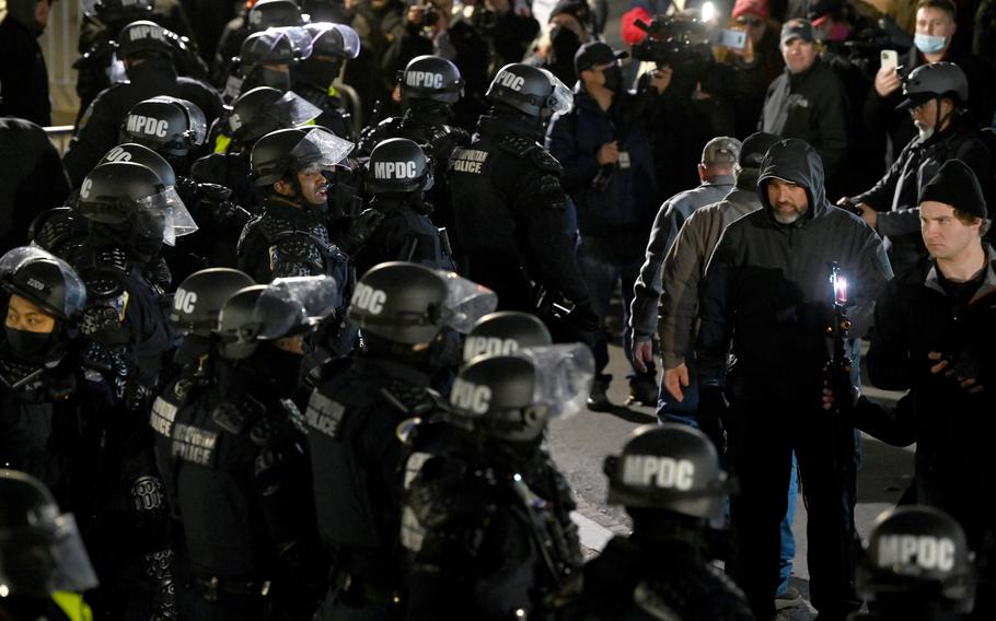 Law enforcement officers and supporters of President Donald Trump stand outside the U.S. Capitol on Jan. 6, 2021, when a violent mob stormed the building. 