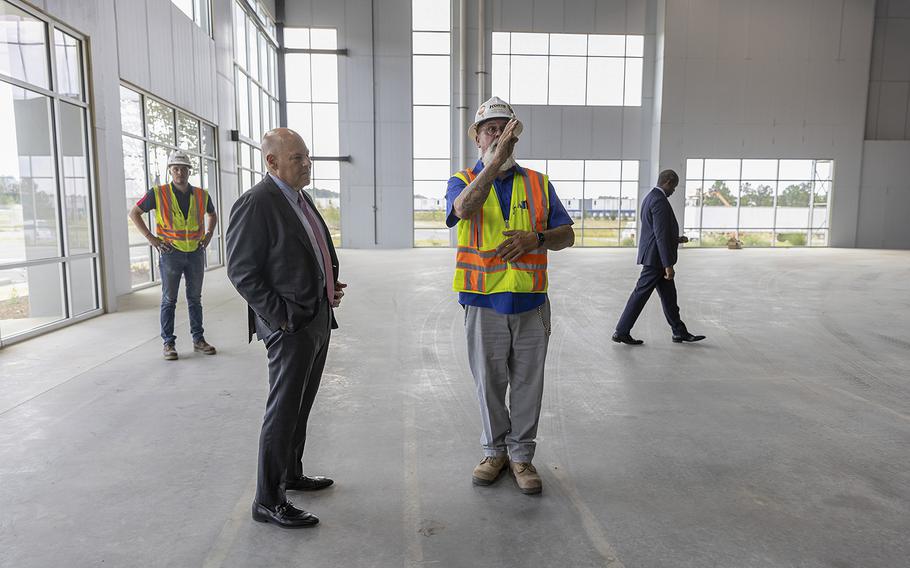 Louis DeJoy is shown around by a superintendent at a new Postal Service facility near Atlanta.