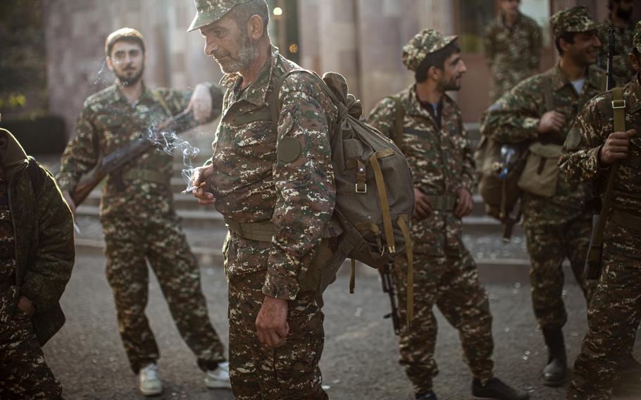 In this Tuesday, Sept. 29, 2020 file photo, ethnic Armenian volunteer recruits gather at a center near Hadrut, self-proclaimed Republic of Nagorno-Karabakh, where they receive their uniforms and weapons before being dispatched to the frontline. Armenia accused neighboring Azerbaijan of systematically promoting ethnic hatred against Armenia citizens, as the two nations that fought a six-week war last year faced off at a United Nations court on Thursday Oct. 14, 2021.