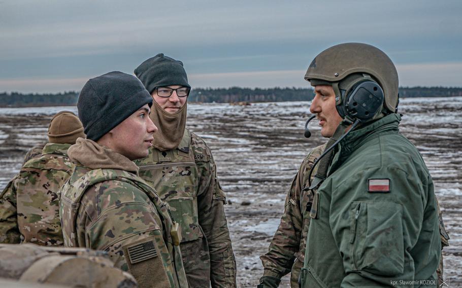 A Polish tank crew speaks with soldiers from the U.S. Army's 1st Battalion, 35th Armored Regiment at Nowa Deba Training Area on Jan. 17, 2024. The Polish crew's training culminated this week with live-fire drills at the base. 