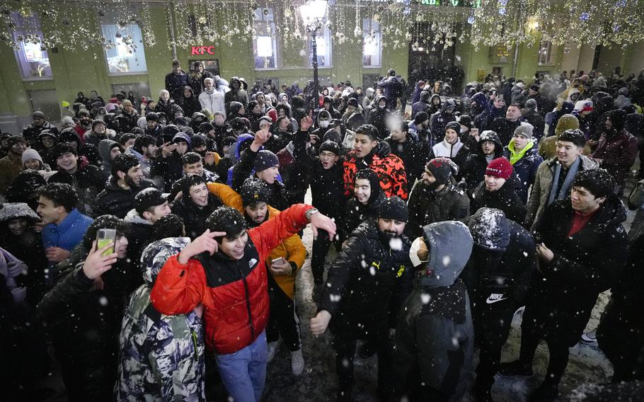 People celebrate the New Year in Nikolskaya street near an empty Red Square due to pandemic restrictions during New Year celebrations in Moscow, Russia, Saturday, Jan. 1, 2022. Russia's state coronavirus task force has registered a total of about 10.5 million confirmed infections and 308,860 deaths, but the state statistics agency that uses broader criteria in its tallying system has reported nearly 626,000 virus-linked deaths in Russia since the start of the pandemic. (AP Photo/Alexander Zemlianichenko Jr)