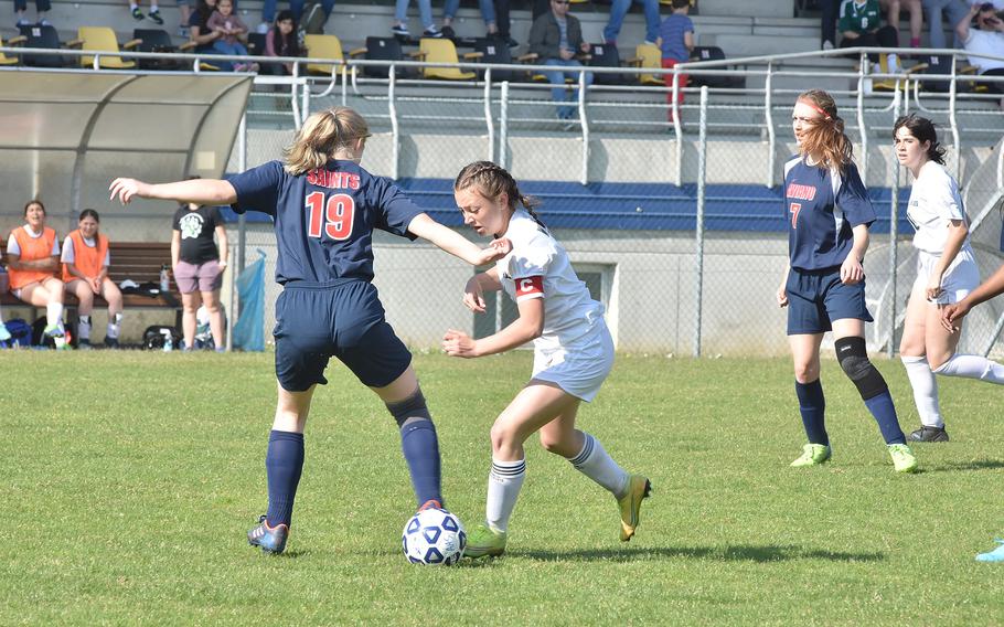 Naples' Emma Kasparek, who scored three of her team's goals, crosses up Aviano's Audrey Belden-Cruz during the Wildcats' 5-3 win over the Saints on Saturday, Apriil 16, 2022, in Aviano, Italy.