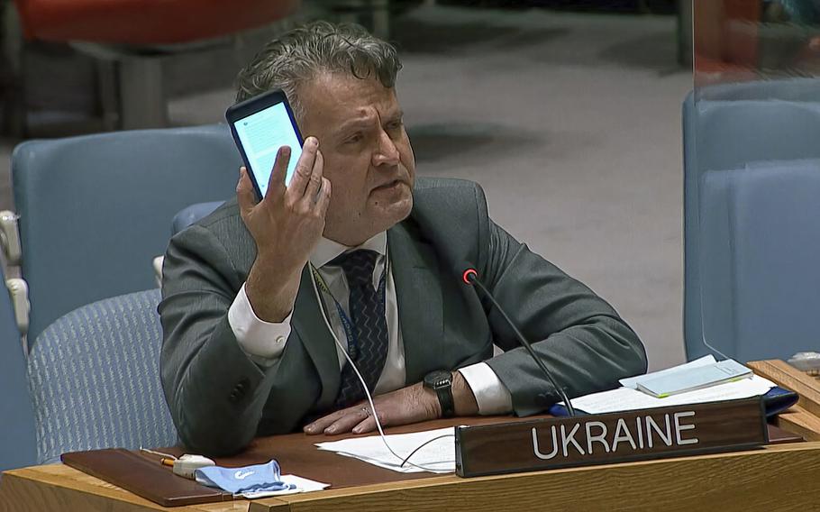 In this image from UNTV video, Ukraine's Ambassador to the United Nations Sergiy Kyslytsya, holds up a phone as he speaks an emergency meeting of the U.N. Security Council Wednesday, Feb. 23, 2022, at U.N. headquarters.