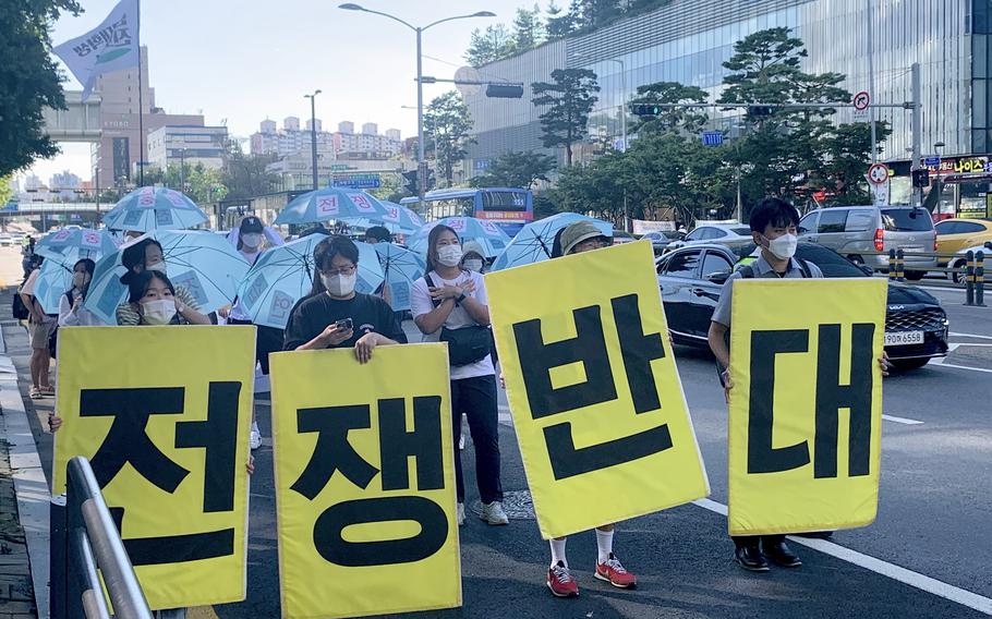 Protesters carry signs spelling out "anti-war" during a march toward the War Memorial Hall of Korea and the country's presidential office in Seoul, South Korea, Aug. 27, 2022. 
