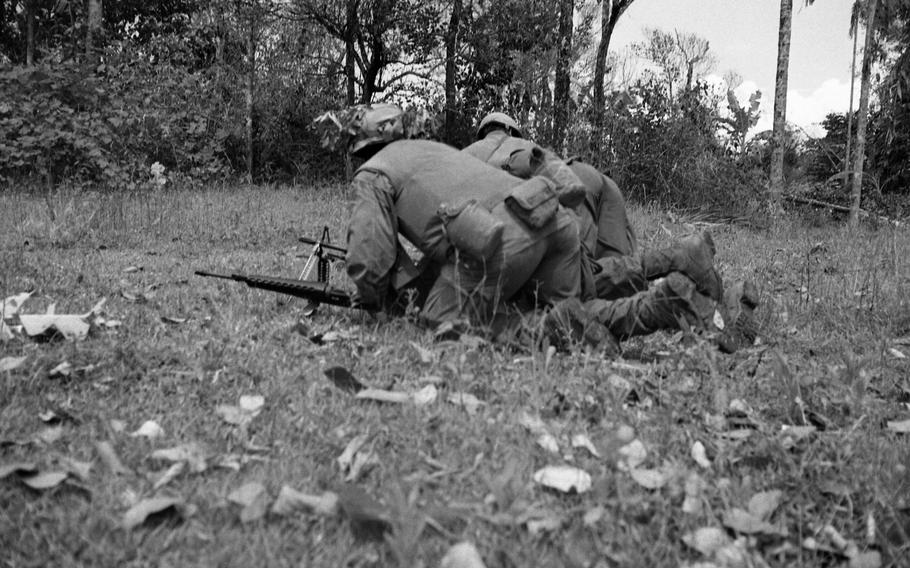 Marines of Alpha Company, 1st Battalion, 9th Marines fire at North Vietnamese Army soldiers. A claymore mine explosion minutes earlier cost the life of the platoon sergeant of Alpha Company.