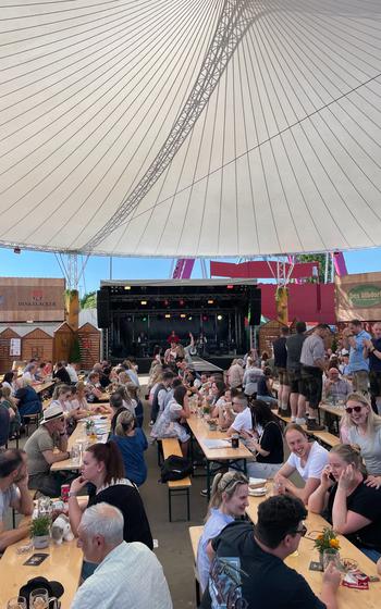 Many people talking and drinking beer in a beer tent