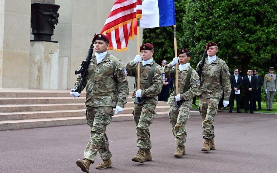 
Uniformed troops march with flags.