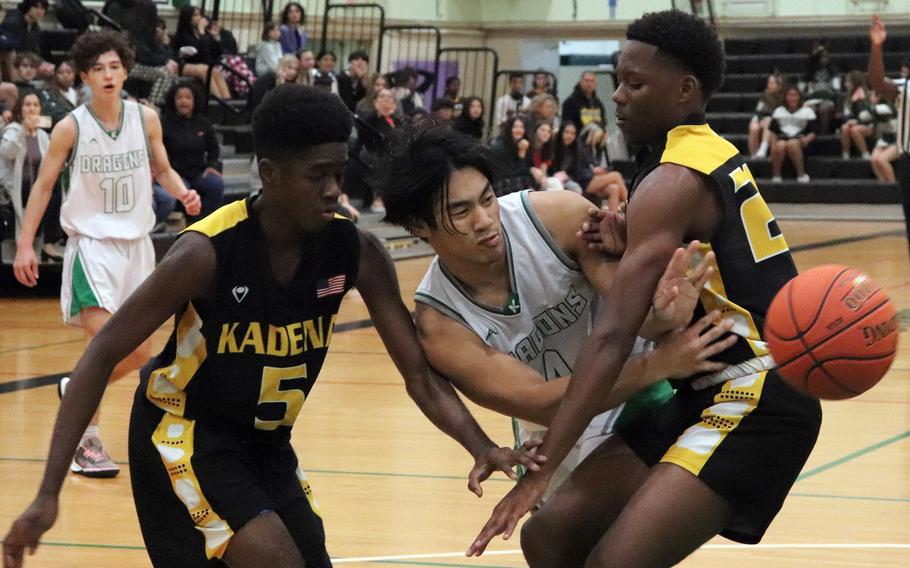 Kubasaki's Aiden Sablan passes to his left between Kadena's Cedric Dorelien and Javontay Vickers during Thursday's Okinawa boys basketball game. The Panthers won 61-44.