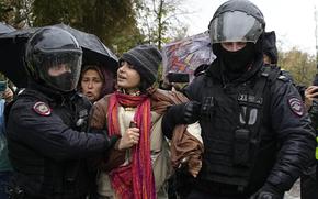 Police officers detain a demonstrator during a protest against a partial mobilization in Moscow, Russia, Saturday, Sept. 24, 2022. 