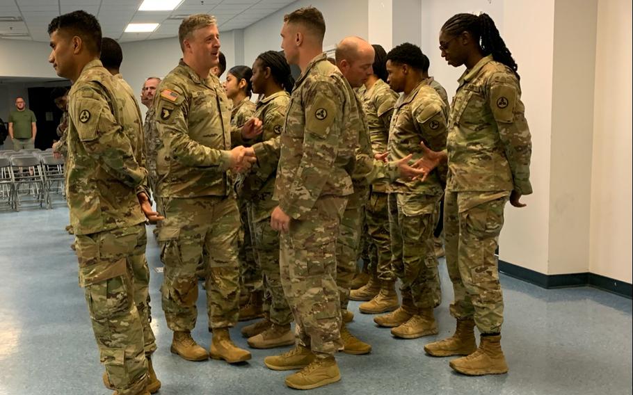 Lt. Col. Jim Grube, commander of the 264th Combat Sustainment Support Battalion, hands out coins to returning members of the 54th Quartermaster Company on April 12, 2024, at the Family Life Center on Fort Gregg-Adams, Va.