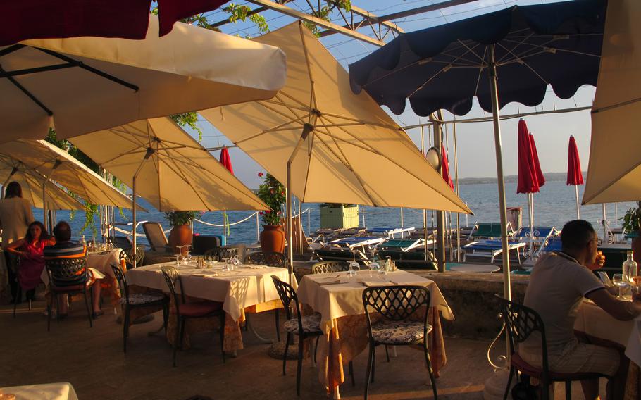 Hotel Catullo in Sirmione, Italy, serves diners on a covered patio close to Lake Garda, where the sun still shines bright at 7 p.m. in the summer.