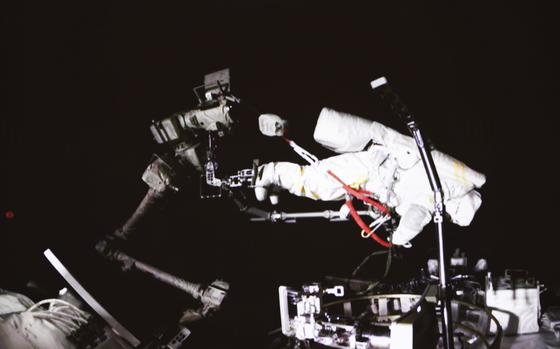 In this photo released by China's Xinhua News Agency, a screen at the Beijing Aerospace Control Center in Beijing shows Chinese astronaut Cai Xuzhe conducting extravehicular activities, also known as a spacewalk, around the space station lab module Wentian, Saturday, Sept. 17, 2022.