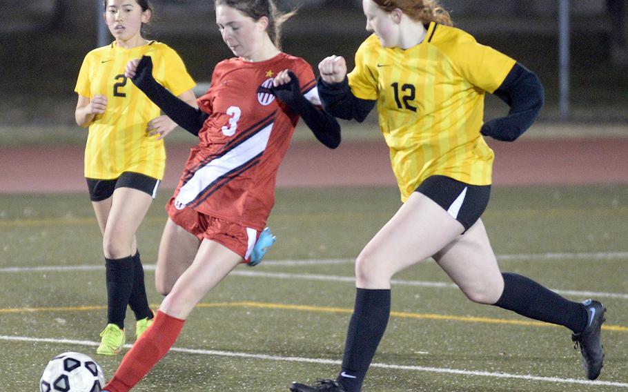 Nile C. Kinnick's Bridget Pidgeon boots the ball between Robert D. Edgren's Kyla Smith and Hannah Lee during Friday's DODEA-Japan soccer match. The Red Devils won 6-0.