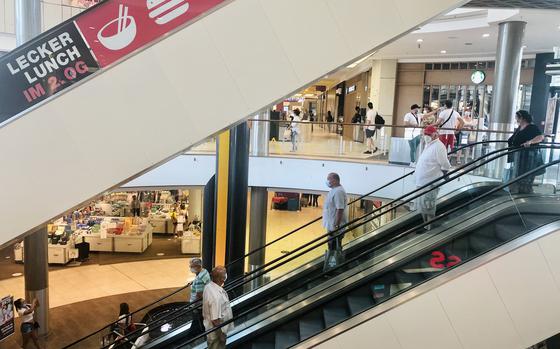 Shoppers ride the escalators in the K in Lautern mall in Kaiserslautern, Germany. Under new rules in the state of Rheinland-Pfalz, shops and restaurants will no longer have to shut down when coronavirus numbers tick up above certain levels.