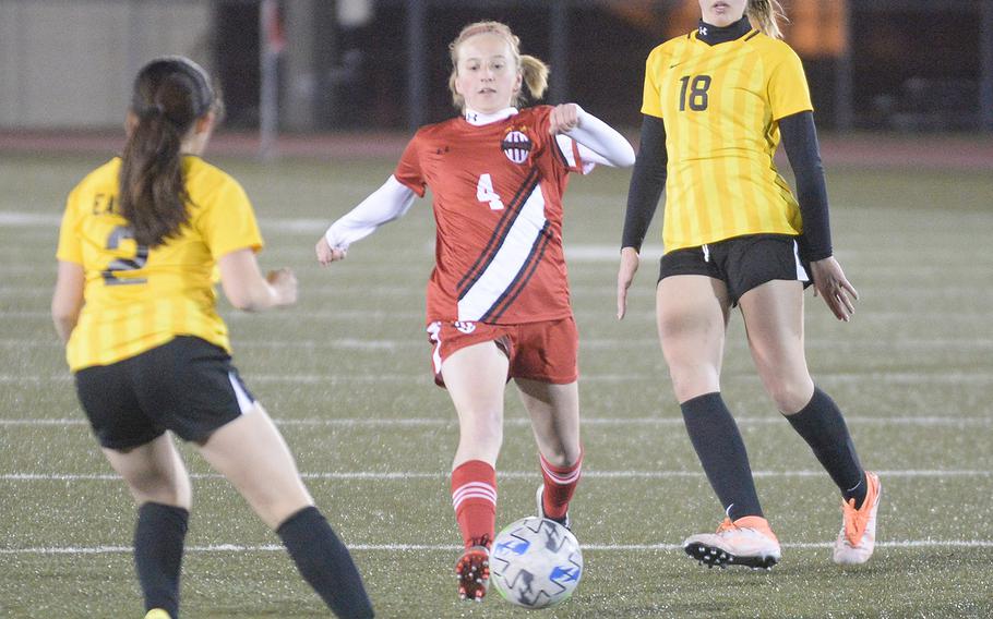 Nile C. Kinnick's Ainsley Rochholz boots the ball between Robert D. Edgren's Kyla Smith and Hannah Lee during Friday's DODEA-Japan soccer match. The Red Devils won 6-0.