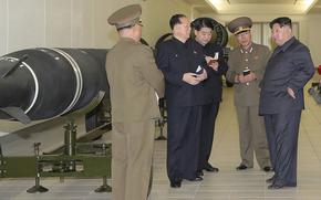 This photo provided on Tuesday, March 28, 2023, by the North Korean government, North Korean leader Kim Jong Un, right, talks with military officials at a hall displayed what appeared to be various types of warheads designed to be mounted on missiles or rocket launchers on March 27, 2023, in undisclosed location, North Korea.
