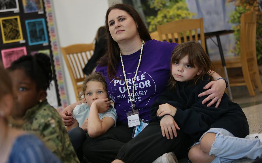 Makayla Torrey, facilitator, cuddles with Kynlee Franklin, 7, left, and Victoria Kaiser, 8, during reading time at the Armed Services YMCA’s after-school program at Three Oaks Elementary School called Operation Hero, designed to help elementary age children cope with the deployment of one or both parents or other stress, on Thursday, April 11, 2024, in Portsmouth, Va.