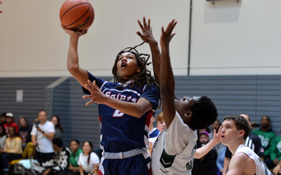 Aviano’s Andrew Walker goes in for a basket against Naples’ Robert Oliver in a Division II semifinal at the DODEA-Europe basketball championships in Ramstein, Germany, Feb. 17, 2023. Naples beat Aviano 68-49 to advance to Saturday’s final against AOSR.