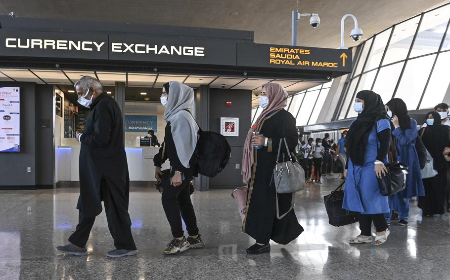 Refugees who fled Afghanistan walk through the terminal to board a bus after arriving at Dulles International Airport on Aug. 27, 2021, in Chantilly, Va. 