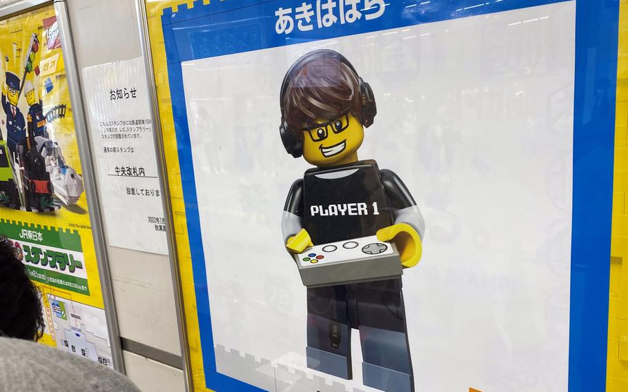 People line up to collect a special Lego stamp at Akihabara Station in central Tokyo. Akihabara's minifigure for the stamp rally is called "Pro Gamer."