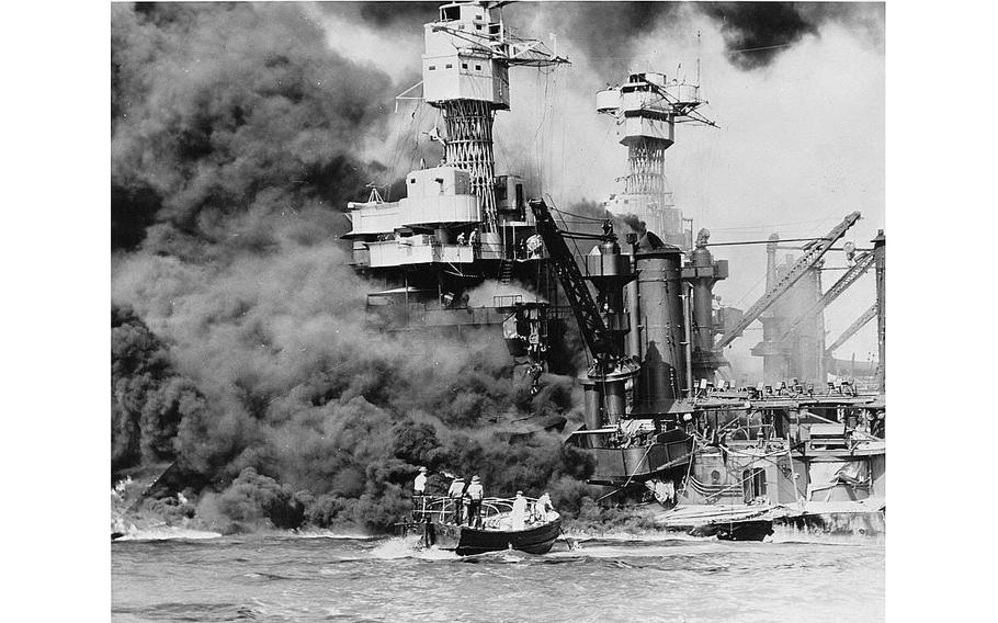 During the Pearl Harbor attack, a small boat rescues a seaman from the 31,800-ton USS West Virginia burning in the foreground. Smoke rolling out amidships shows where the most extensive damage occurred. Note the two men in the superstructure. The USS Tennessee is inboard.
