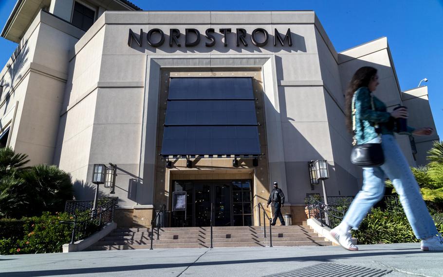 A security guard patrols the front entrance of Nordstrom in Los Angeles on Tuesday Nov. 23, 2021, after an organized group of thieves attempted a smash-and-grab robbery late Monday night.