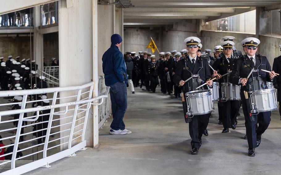 The Navy Band marches and plays.