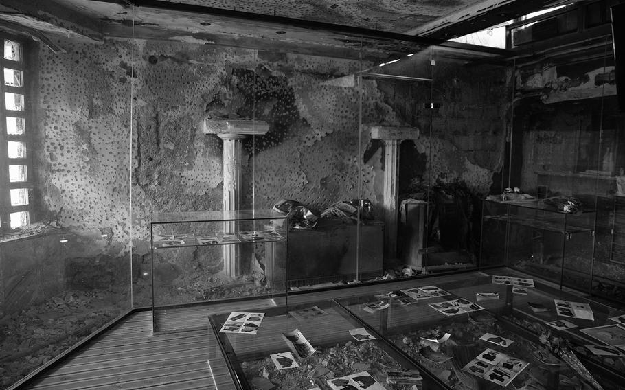 Once a pizzeria, before 44 people were herded inside, shot, and burned. In 2023, a donation allowed Hysni Berisha to encase the bullet-scarred walls in glass and build an elevated walkway over the rubble-strewn floor. 