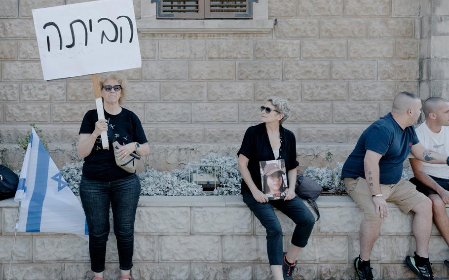 An Israeli woman holds a sign that reads “Home!” during a protest for the release of hostages, in Tel Aviv on Saturday. 