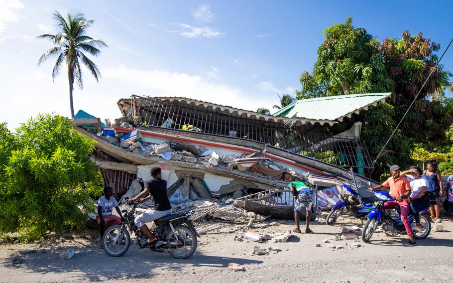 Groups of people observe the effects of a 7.2 magnitude earthquake in Los Cayos, Haiti, on Saturday, Aug. 14, 2021.