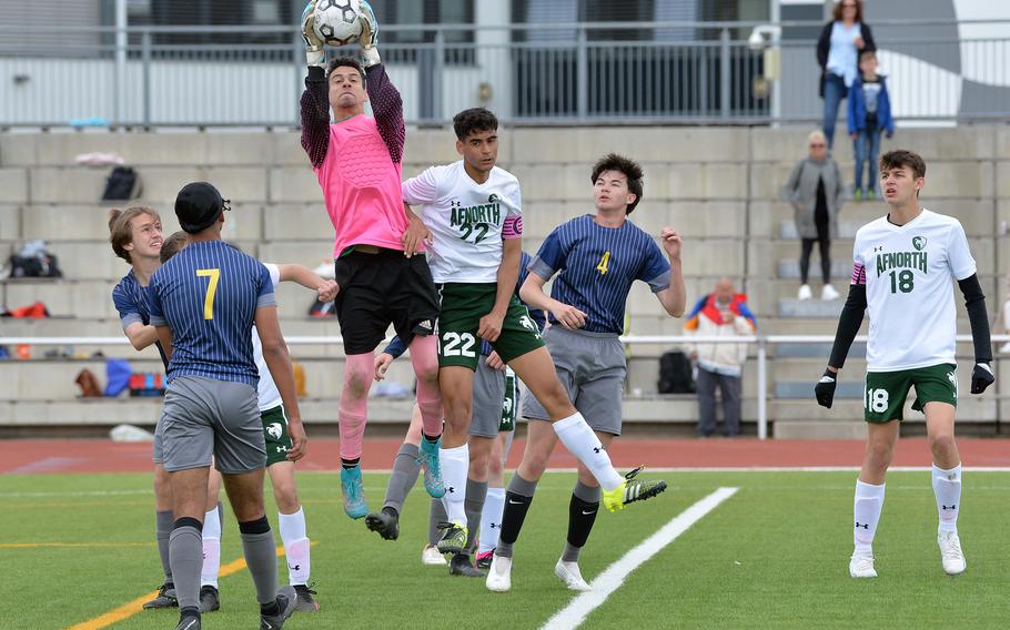 Ansbach keeper Elijah Antonetty goes high to pull down a cross in front of AFNORTH’s Ronnie Macauley as players from both teams watch the action, in the Cougars 5-3 win over the Lions in a Division III semifinal at the DODEA-Europe soccer championships in Kaiserslautern, Germany, May 17, 2023.