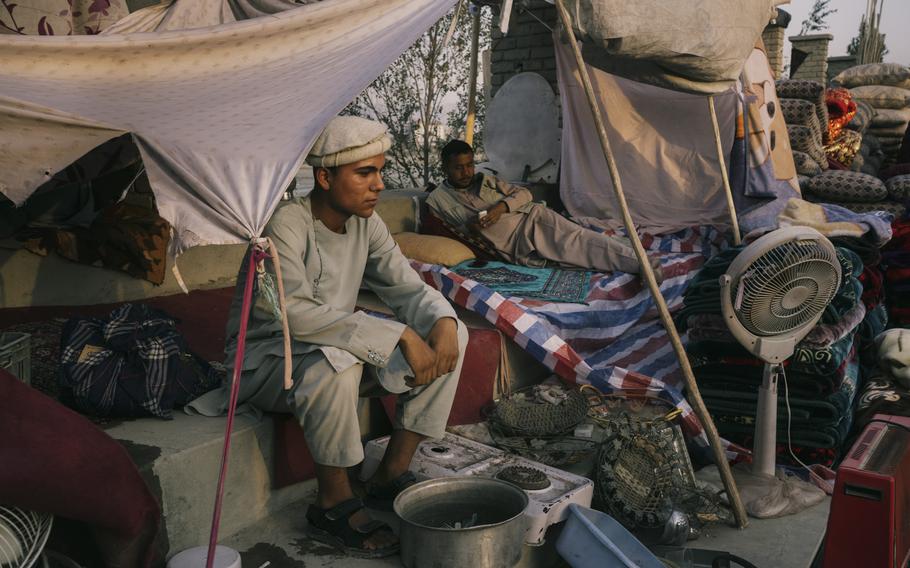 A family waits for buyers on Sept. 29, 2021, in a sprawling market that has appeared in Kabul near Ghazi Stadium.