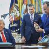 Director of U.S. Federal Marshall Service, Gadyaces Serralta, right, presents President Donald Trump with an honorary badge, as Secretary of Defense Pete Hegseth looks on, in the Oval Office of the White House, Monday, Aug. 25, 2025, in Washington. (AP Photo/Evan Vucci)