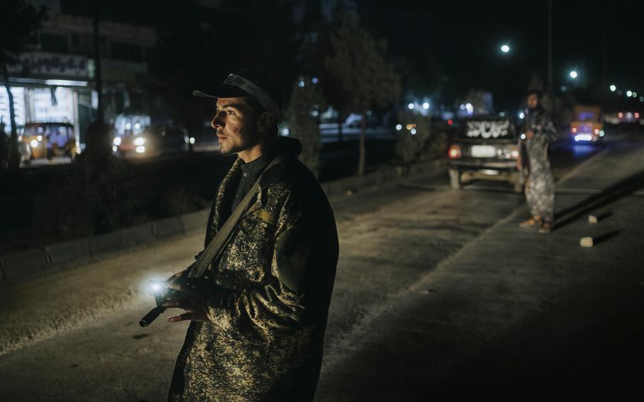 A young Taliban member inspects vehicles at a checkpoint in Kabul, Afghanistan, on Oct. 5.