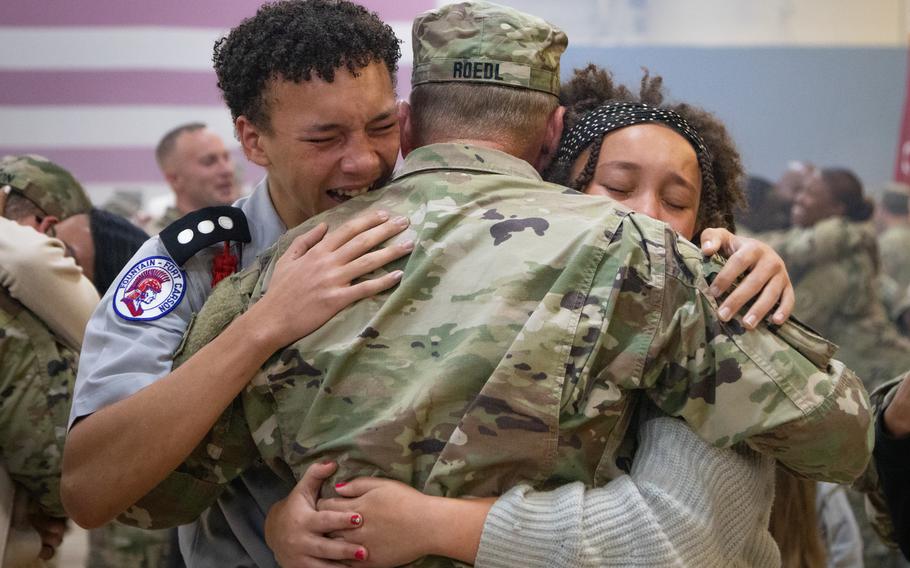 Lt. Col. Kenneth Roedl, the 4th Infantry Division G6 OIC, hugs his children after the division uncasing ceremony in the Special Events Center on Fort Carson, Colorado, Sept. 13, 2023. 