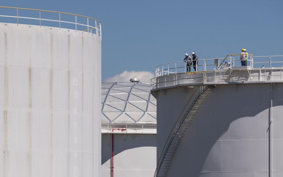 Workers stand on top of a tank at a Colonial Pipeline Inc. facility in Avenel, N.J., on May 12, 2021. 