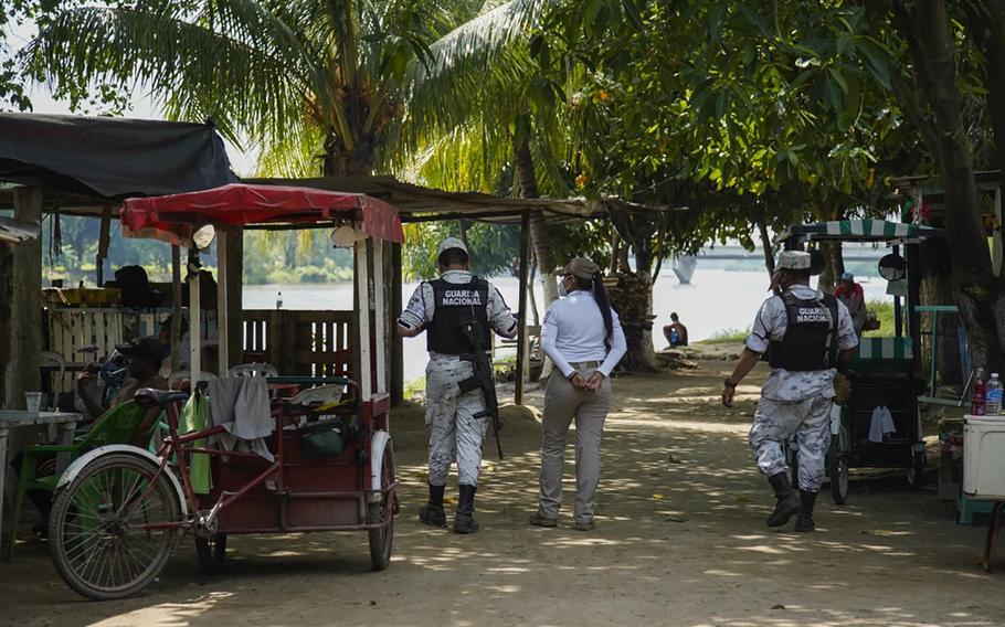 Mexican National Guard and an immigration official patrol the border near the river at Paso del Coyote in Cuidad Hidalgo, Chiapas.