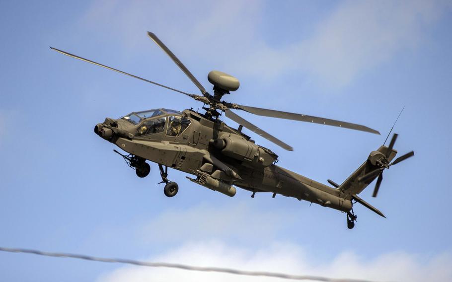 A U.S. Army AH-64 Apache watches over maneuvering infantry units during training.