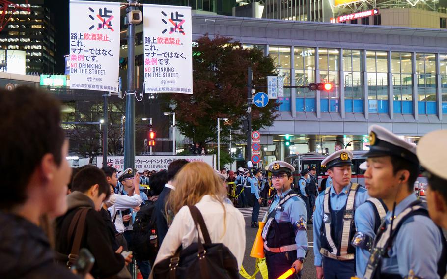 Police control crowds waiting to cross the iconic scramble intersection in Tokyo’s Shibuya ward, Tuesday, Oct. 31, 2023.