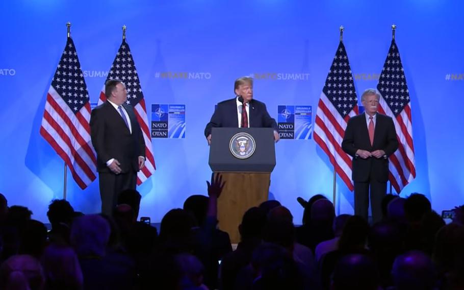 A video screen grab shows then-President Donald Trump speaking from Brussels on July 12, 2018, about getting other NATO members to pay more to fund NATO. At left, is then-Secretary of State Mike Pompeo and at right, then-National Security Adviser John Bolton.
