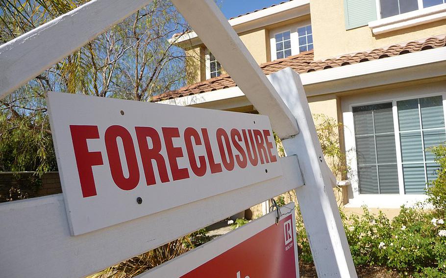 A foreclosure sign in front of a house.