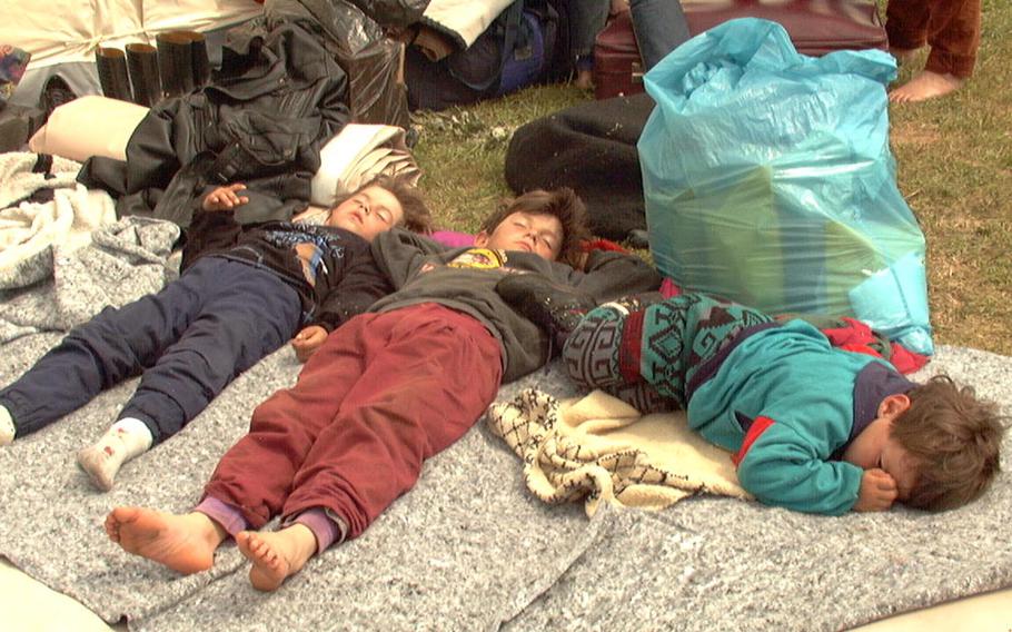 Children nap in the afternoon sun outside their family tent at the Brazda Refugee Camp near Skopje, April 9, 1999.