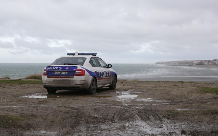 A police car parks over the shore in Wimereux, northern France, Thursday, Nov. 25, 2021 in Calais, northern France. Children and pregnant women were among at least 27 migrants who died when their small boat sank in an attempted crossing of the English Channel, a French government official said Thursday. French Interior Minister Gerald Darmanin also announced the arrest of a fifth suspected smuggler thought to have been involved in what was the deadliest migration tragedy to date on the dangerous sea lane.