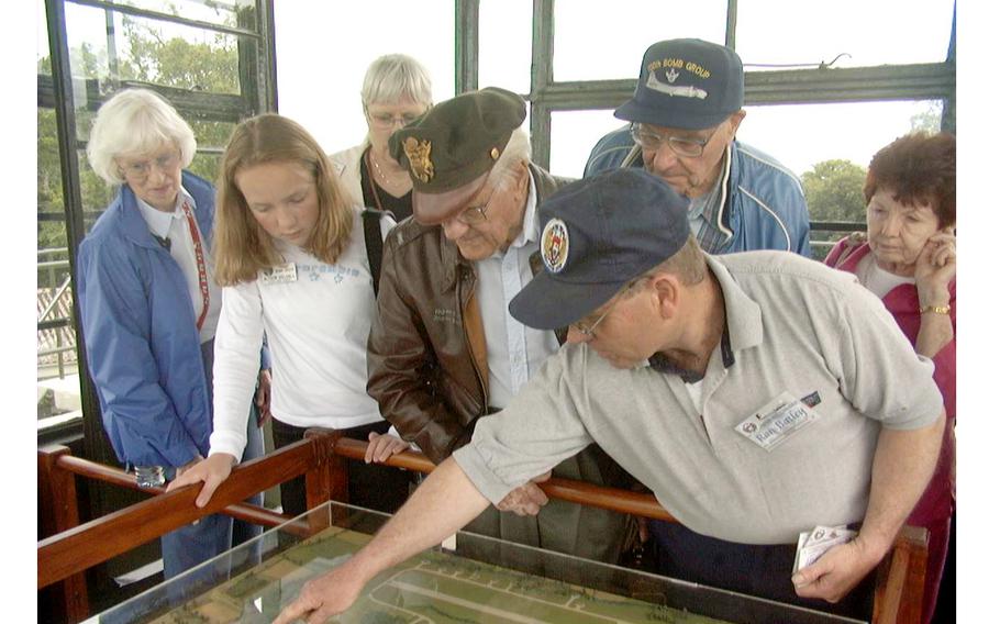 Museum curator Ron Batley, right, explains a display to visitors. Standing next to him in a leather jacket is William “Buzz” Fitzroy, pilot in the 350th Squadron, 100th Bomb Group. On his 35th mission on July 29, 1944, Fitzroy's B-17 was hit by flak and went down. He spent the remainder of the war as a POW in a German prison camp. 