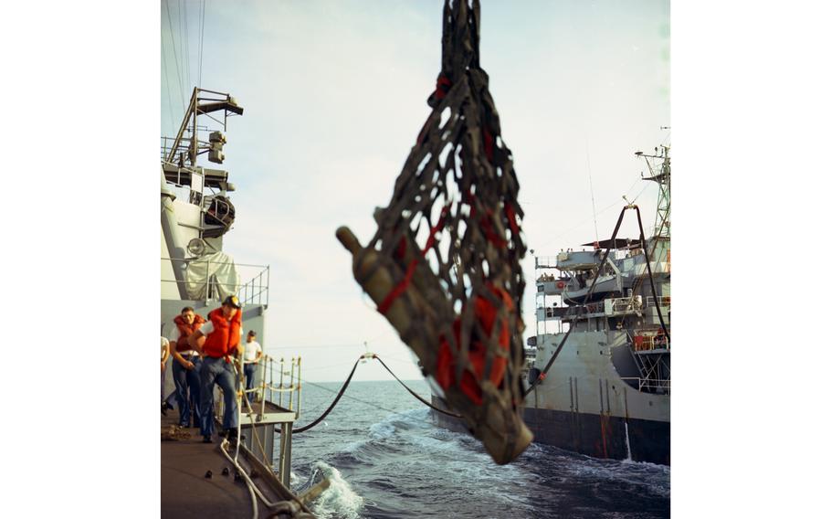 Gas cylinders are hoisted aboard the USS Buchanan destroyer during refeuling operations. The tanker USS Tappahannock can be seen in the background.
