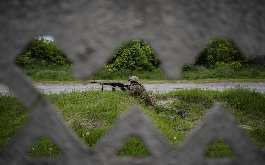 A Ukrainian National Guard soldier guards a position during a reconnaissance mission in a recently retaken village on the outskirts of Kharkiv, east Ukraine, Saturday, May 14, 2022. 